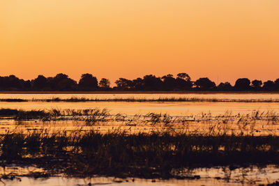 Scenic view of lake against romantic sky at sunset