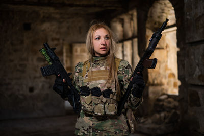 Portrait of young woman standing against blurred background