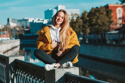 Portrait of smiling young woman sitting outdoors