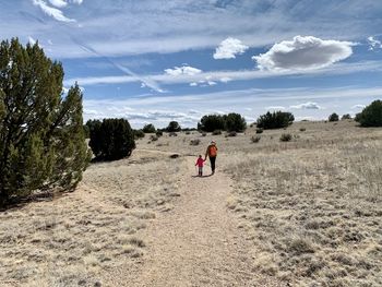 Rear view of woman and child walking on trail 