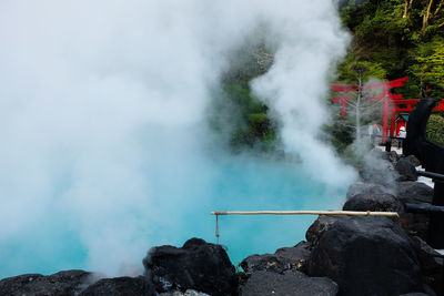 Smoke emitting from hot spring amidst rocks