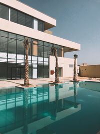 Swimming pool by building against clear sky