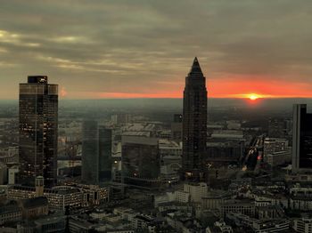 Aerial view of buildings in city at sunset