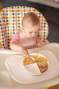 High angle view of cute girl sitting on table