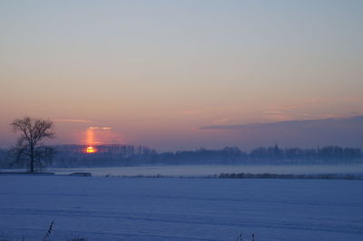 Scenic view of frozen lake against sky during sunset