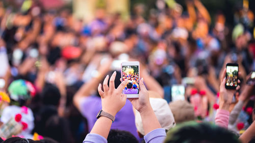 Cropped hands of woman photographing during music festival