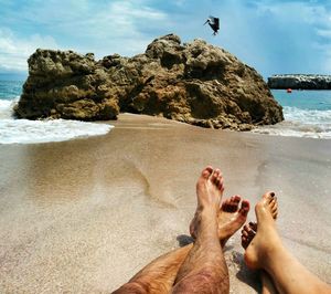 Low section of person relaxing on beach