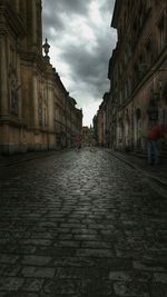 Buildings in city against cloudy sky