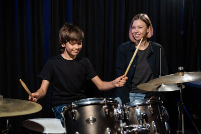 Portrait of young woman playing drum