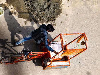 High angle view of man with concession stand walking on road