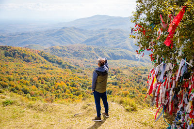 Rear view of woman standing on mountain