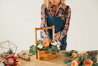 Midsection of woman holding ice cream on table