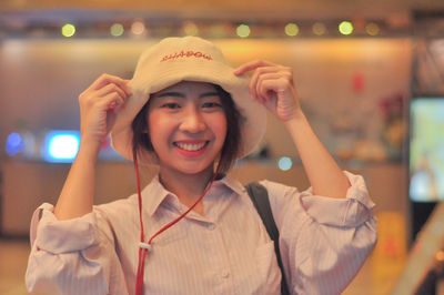 Portrait of smiling young woman holding hat