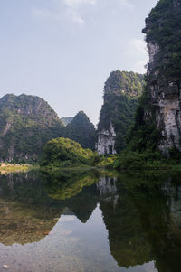 Reflection of trees on mountain against sky