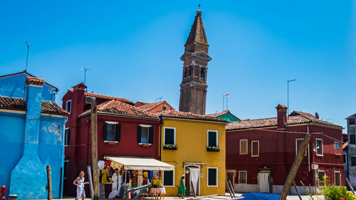 View of buildings in town against blue sky