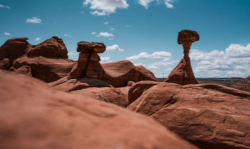 Rear view of man standing on rock against sky