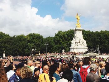 People at town square against sky in city