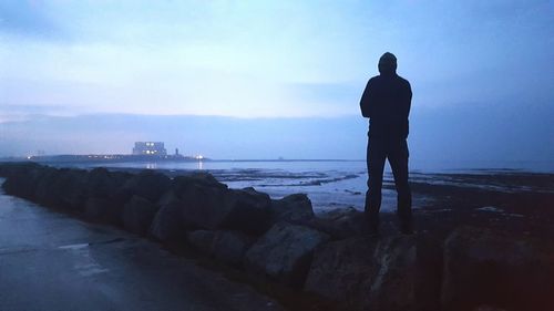 Rear view of silhouette man standing on beach