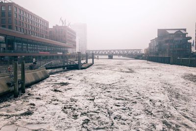 Snow covered city against clear sky