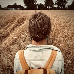 Rear view of woman standing in farm