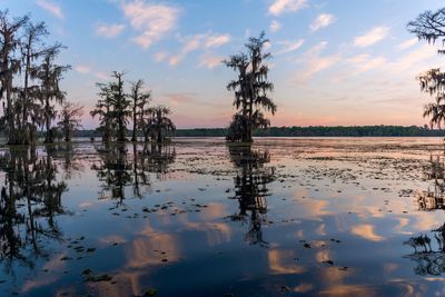 Scenic view of calm lake against cloudy sky