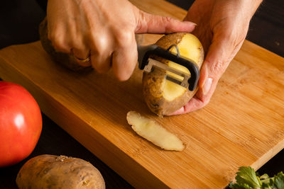 Cropped hands of man preparing food on cutting board