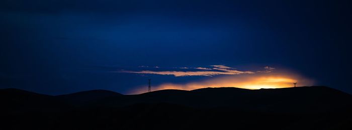Sun shining through clouds over mountains