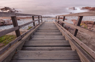 Wooden footbridge leading towards water