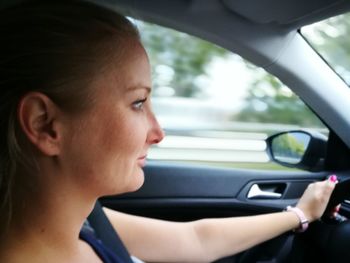 Close-up of young woman using smart phone in car