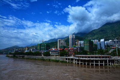 River by buildings against sky