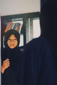 Close-up portrait of a smiling young woman at home