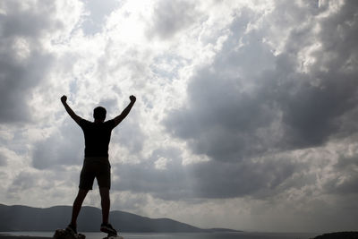 Rear view of silhouette man standing against sky