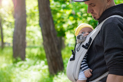 Father carrying his child in a baby sling