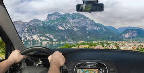 Midsection of man driving car against mountains