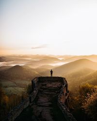 Rear view of silhouette man at observation point during sunset