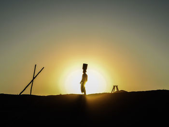 Silhouette man photographing at sunset