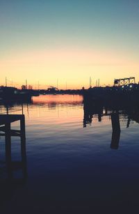 Pier in sea at sunset