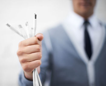 Midsection of businessman holding syringe against white background