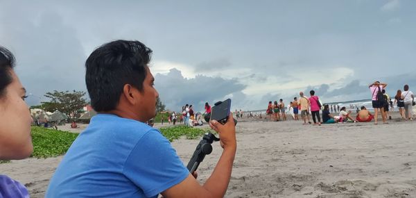 People at beach against sky