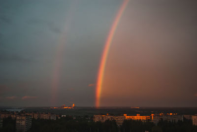 Rainbow over cityscape against sky