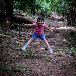 Full length of young woman exercising in forest