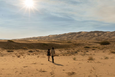 Rear view of couple walking on desert
