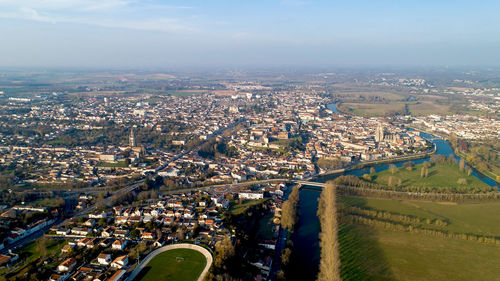 High angle view of city by river against sky