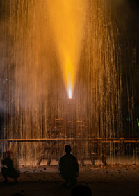 Rear view of man standing at night