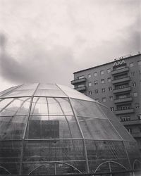 Low angle view of modern building against cloudy sky