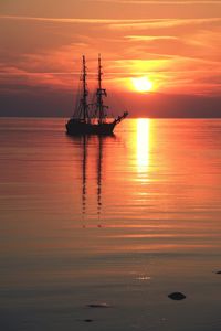 Reflection of clouds in sea at sunset