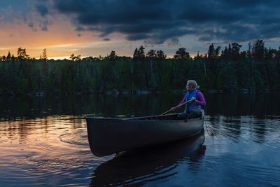 Scenic view of woman in canoe on lake
