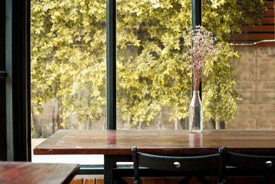 Empty chairs and tables in glass window