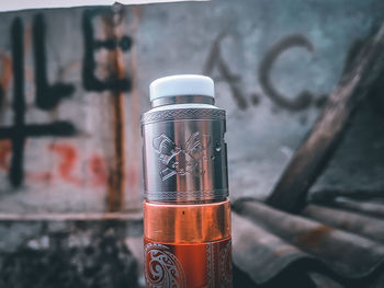 Close-up of orange bottle against wall