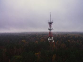 Communications tower on field against sky